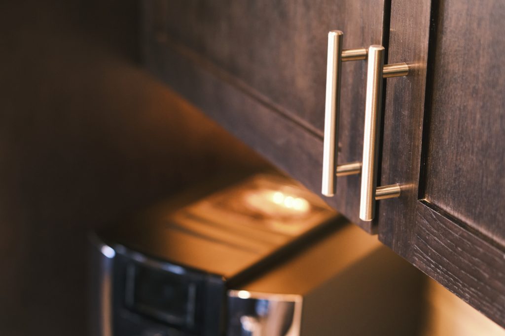 A close up of a kitchen cabinet with brass handles.