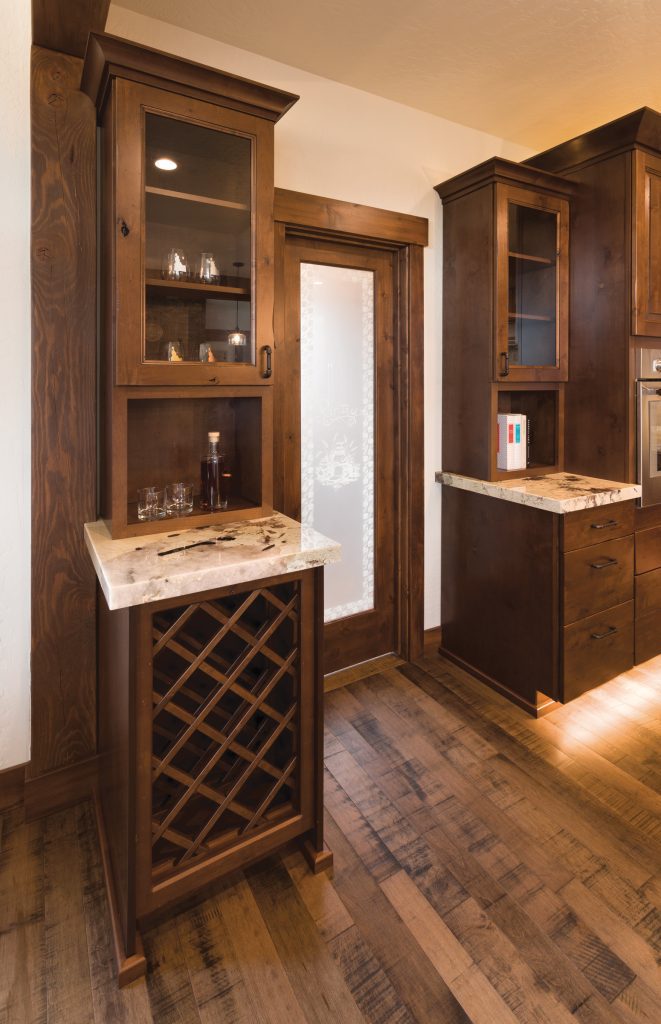 A kitchen with wooden cabinets and a wine rack.