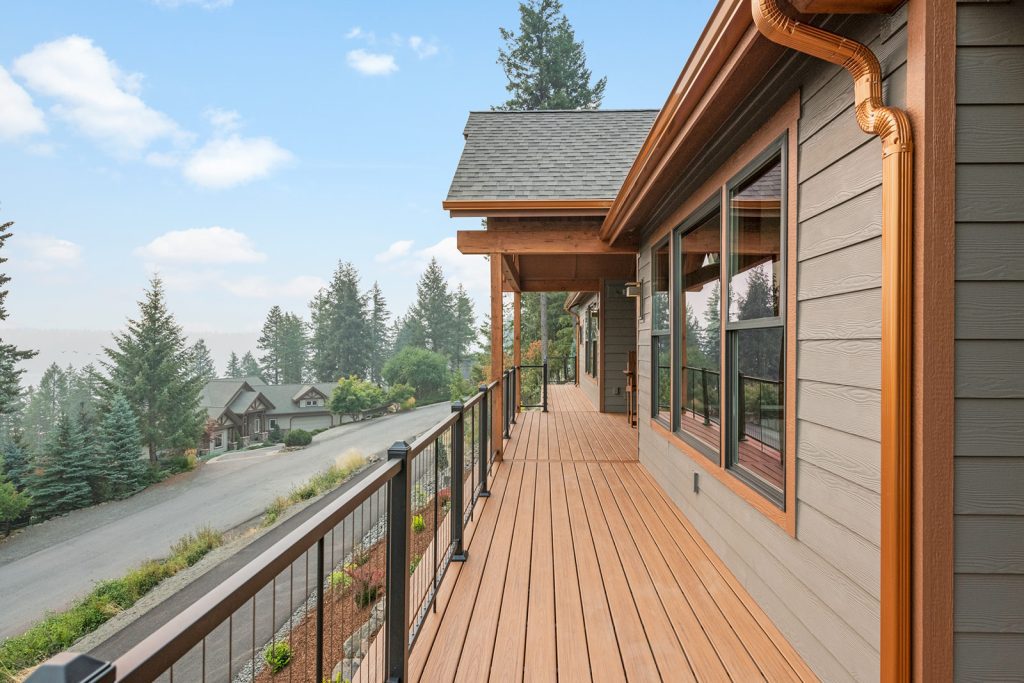 A deck with a railing and a view of the mountains.
