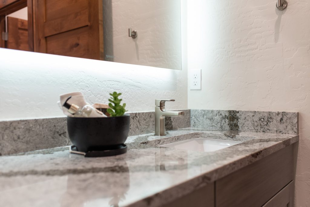 A bathroom with granite counter tops and a sink.