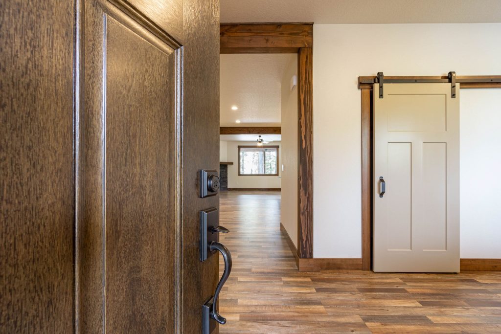 A hallway with wood floors and a sliding barn door.