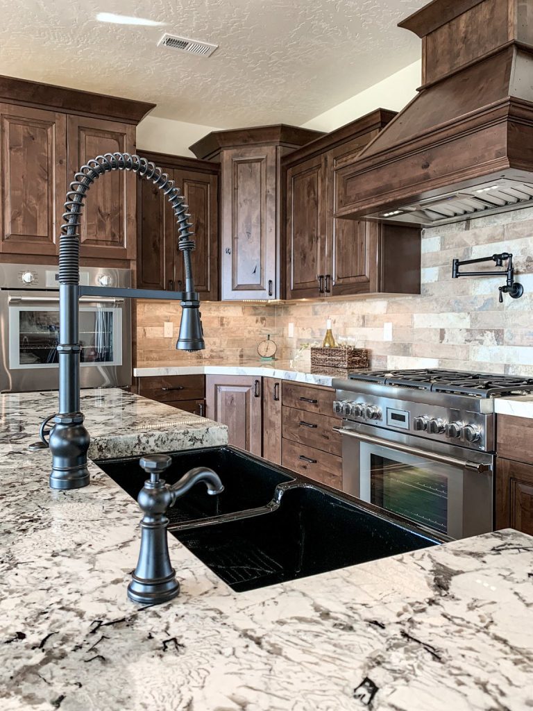 A kitchen with granite counter tops and wood cabinets.