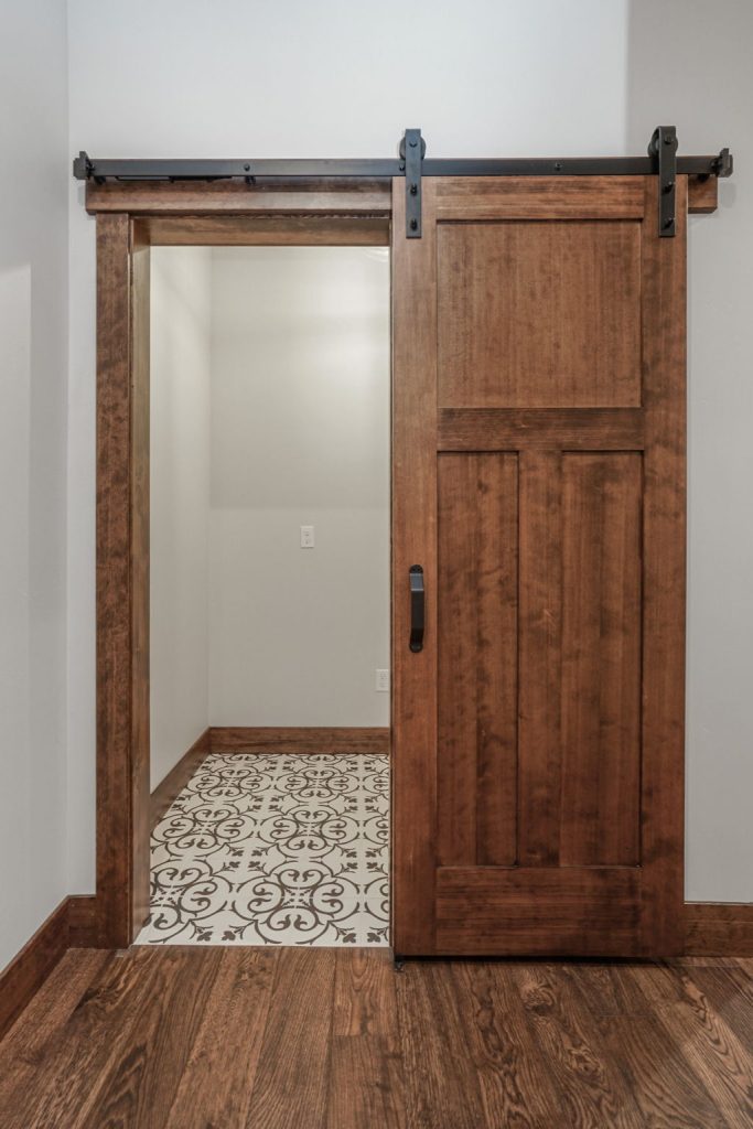 A sliding barn door in a room with hardwood floors.