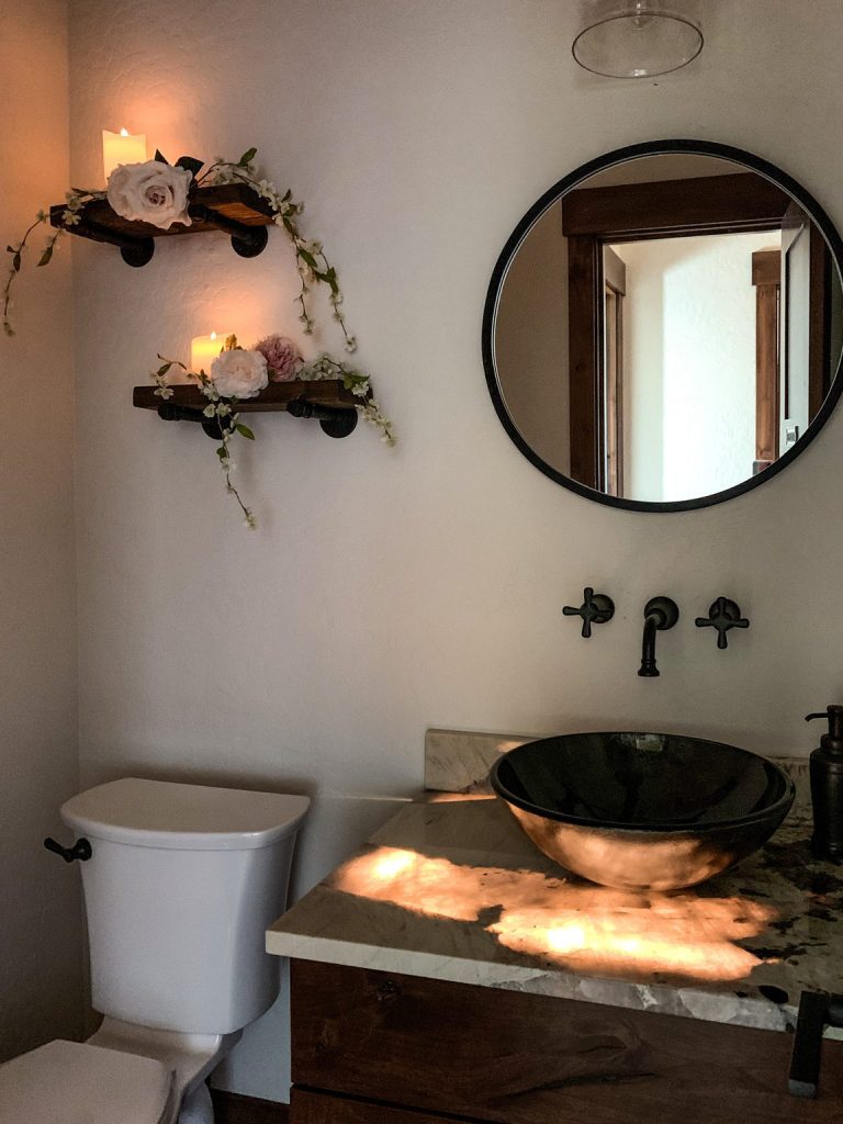 A bathroom with a sink, toilet and a mirror.