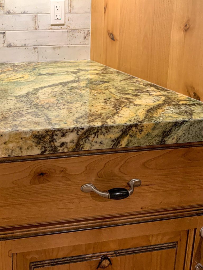 A granite counter top in a kitchen with wooden cabinets.