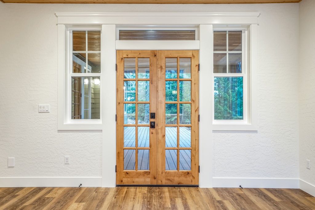 A wooden door in a room with hardwood floors.