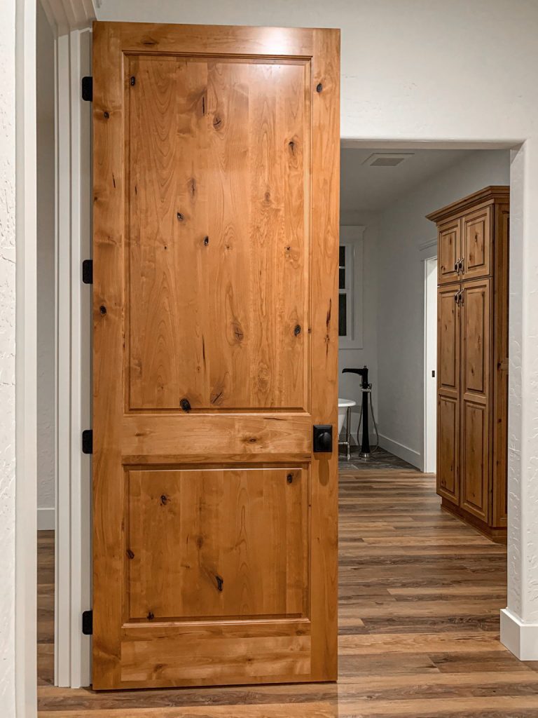 A wooden door in a room with hardwood floors.
