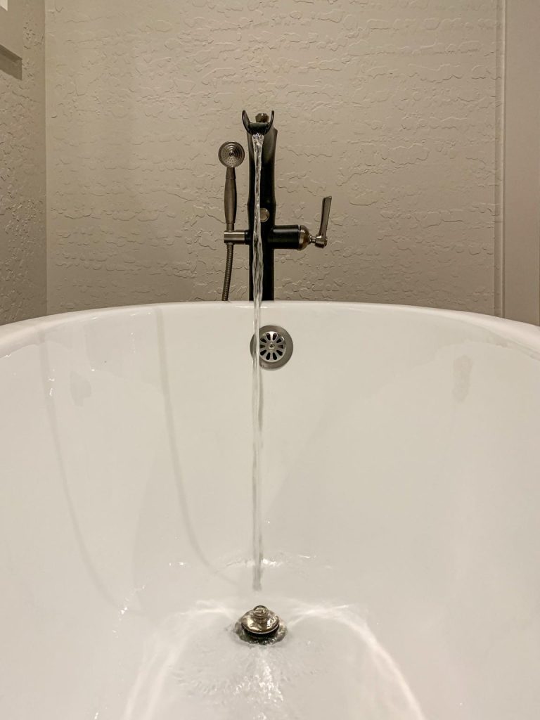 A white bathtub with a faucet in the middle of it.