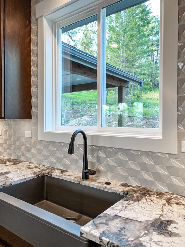 A kitchen with granite counter tops and a window.