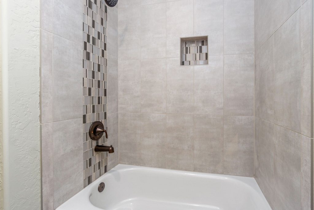 A tiled bathroom with a tub and shower.