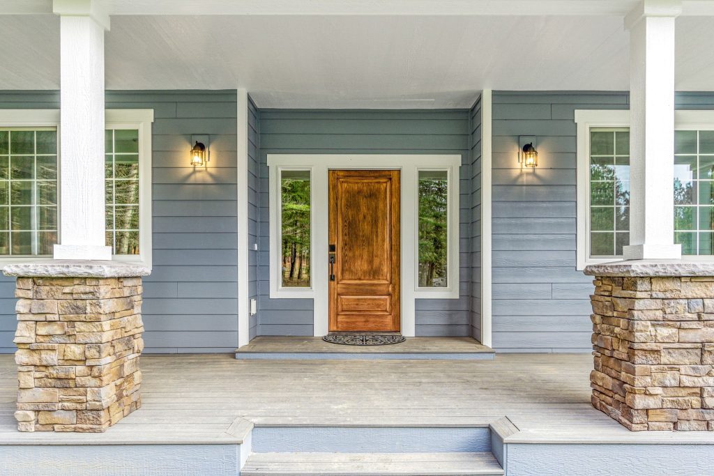 The front porch of a home with stone steps and a wooden door.