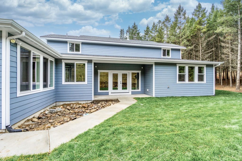 A home with blue siding and a grassy yard.