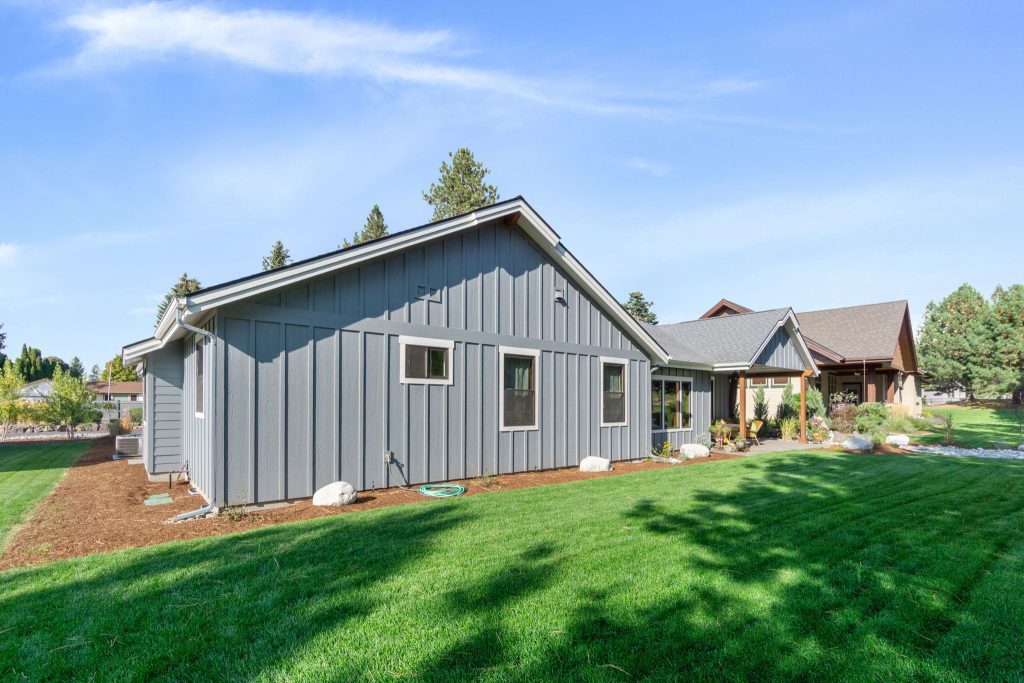 A home with a gray siding and a grassy yard.
