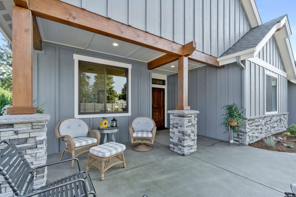 The front porch of a home with gray siding.
