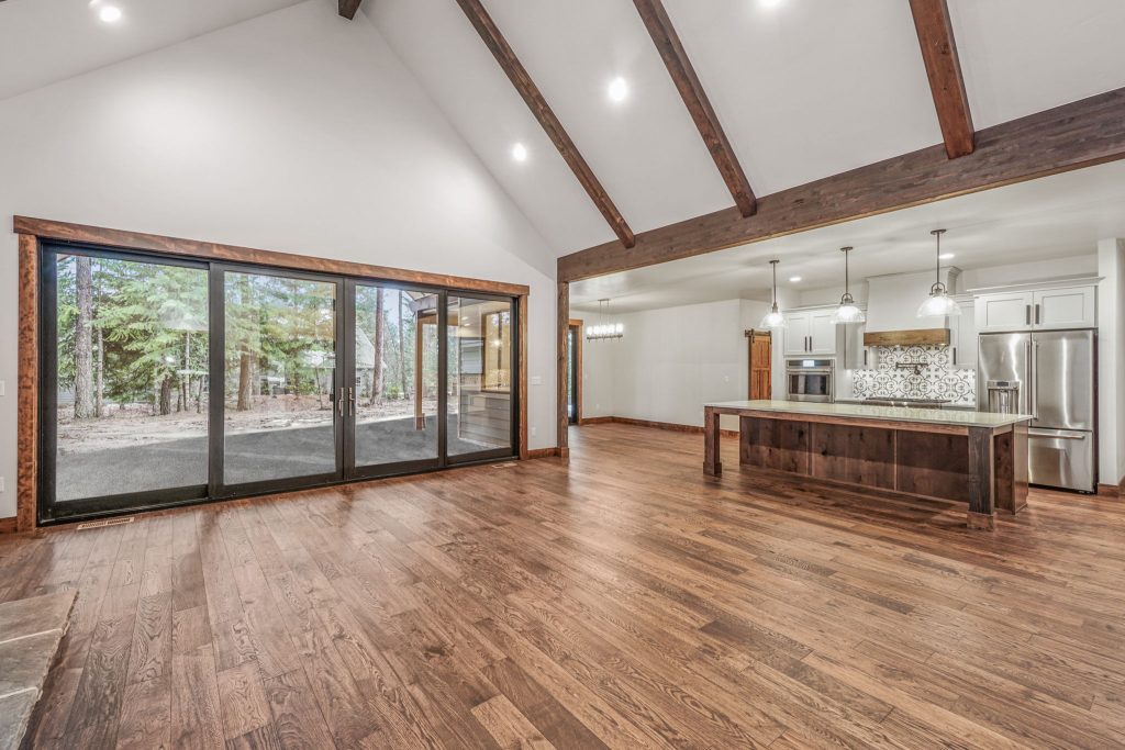 A large open kitchen with hardwood floors and a sliding glass door.