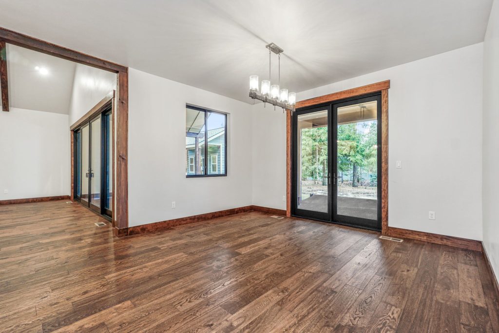 An empty room with wood floors and sliding glass doors.