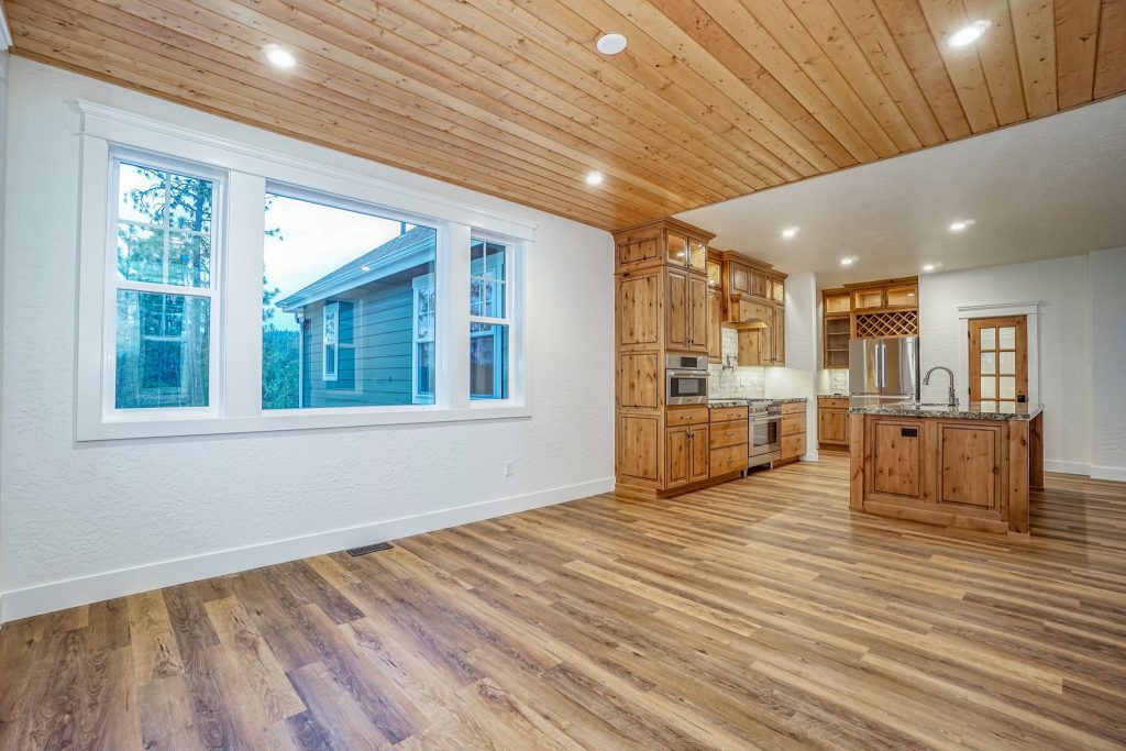 An empty kitchen with wood floors and a wood ceiling.