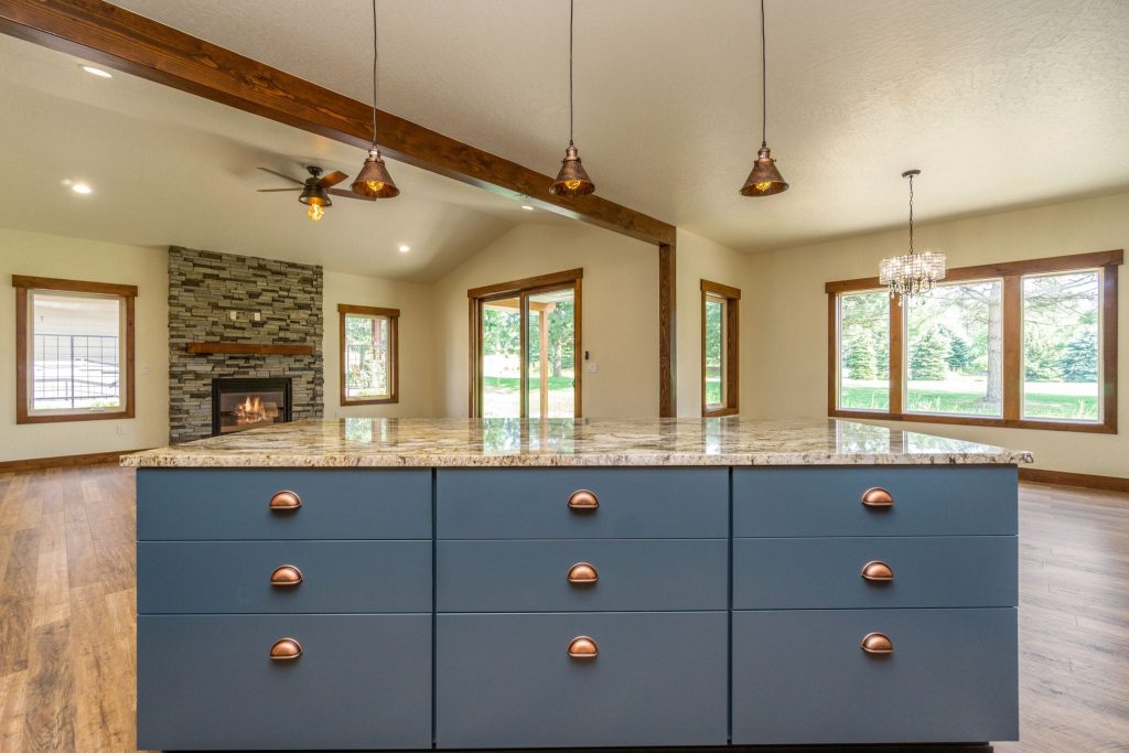 A kitchen with blue cabinets and hardwood floors.