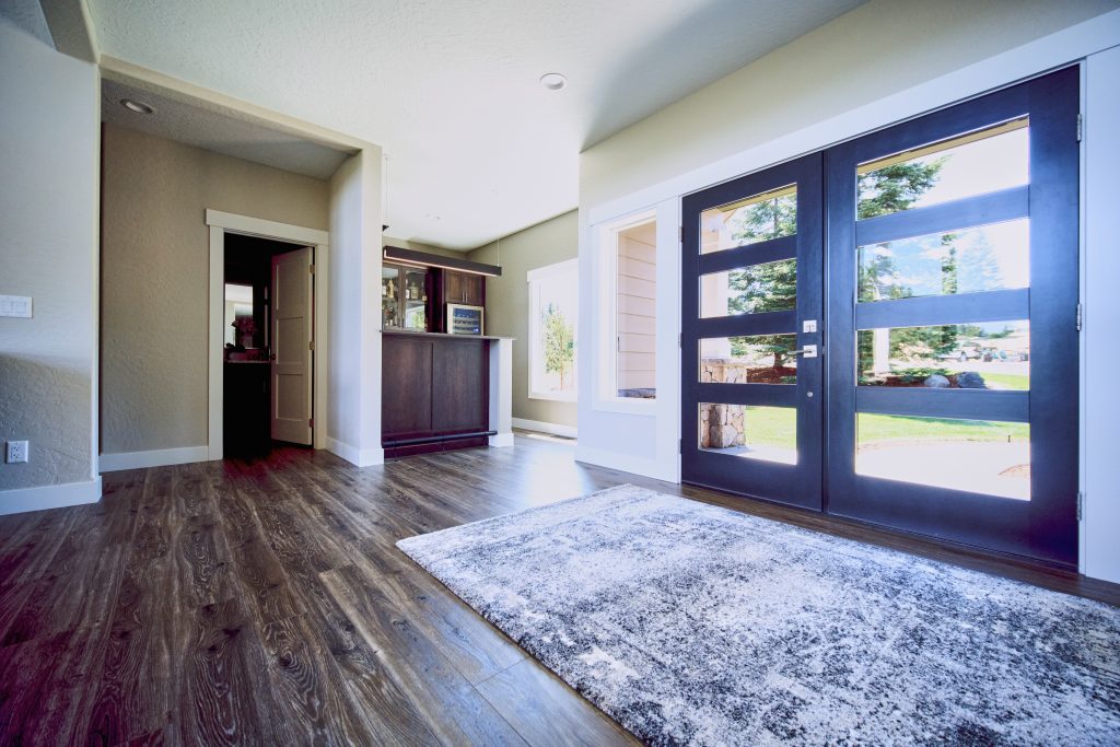 An entryway with hardwood floors and a black door.