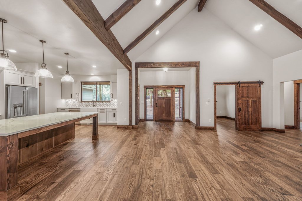 A large open kitchen with wood floors and vaulted ceilings.