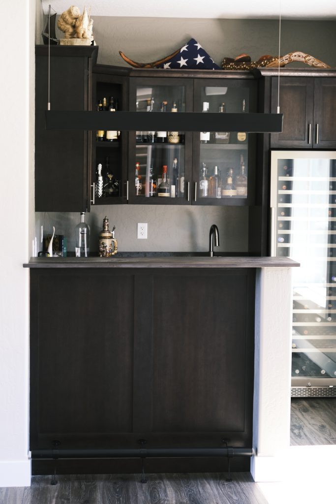 A kitchen with a bar and a refrigerator.