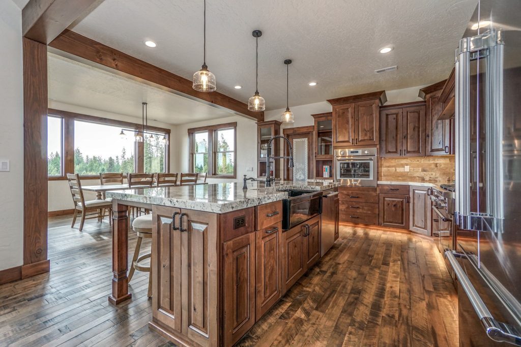 A large kitchen with wood floors and wooden cabinets.