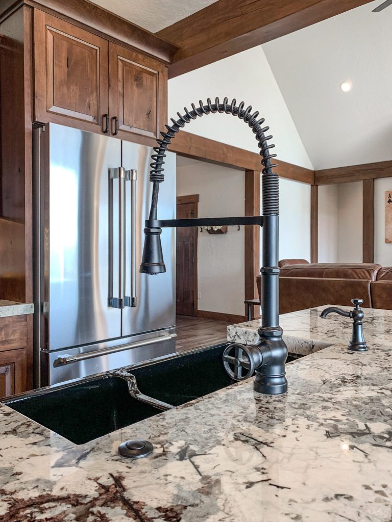 A kitchen with a granite counter top and stainless steel sink.