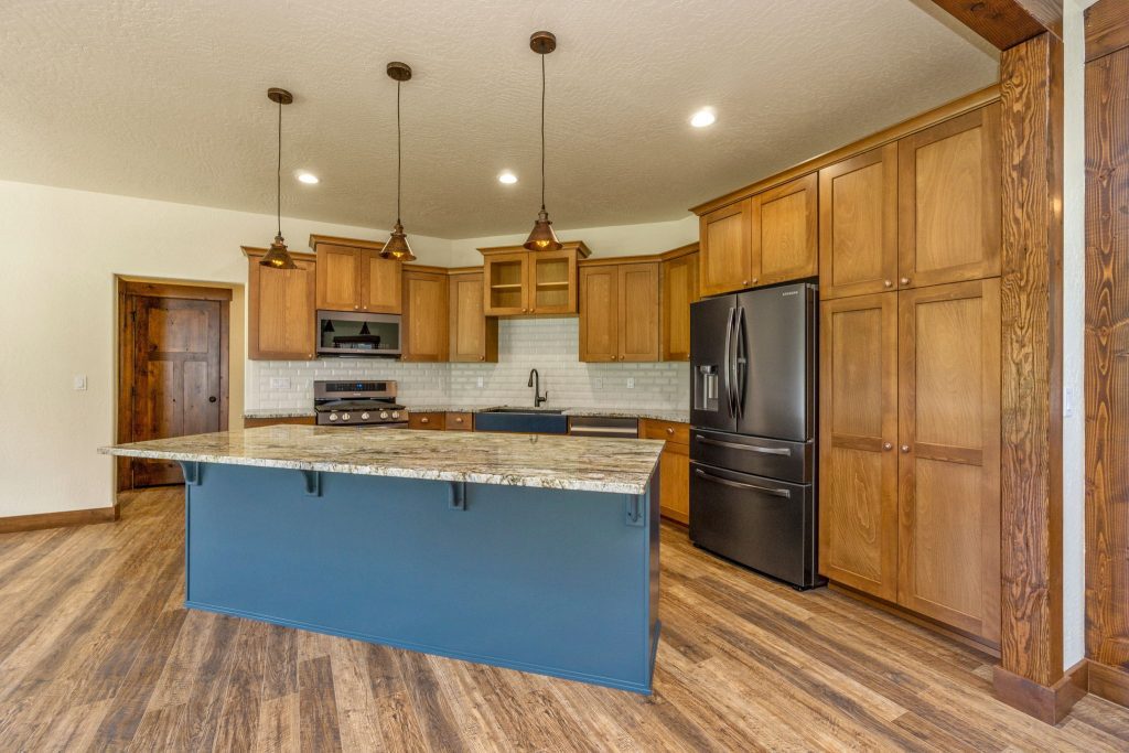 A kitchen with wood cabinets and a blue island.