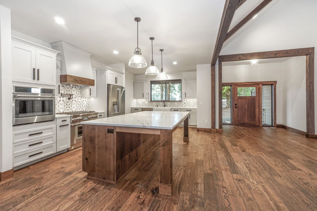 A kitchen with wood floors and wooden beams.