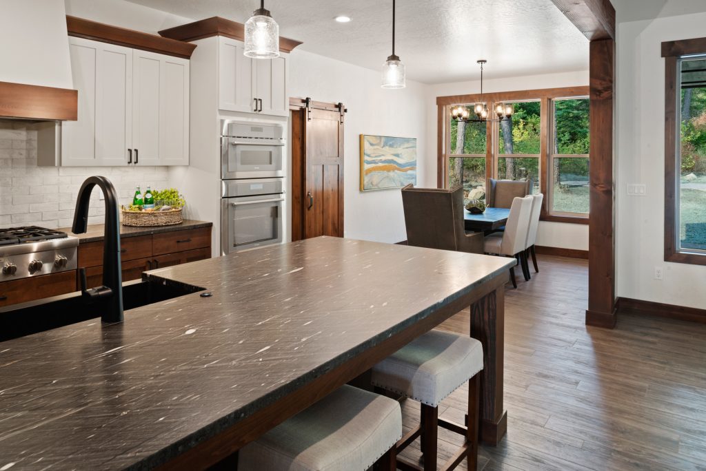 A kitchen with black counter tops and wooden cabinets.