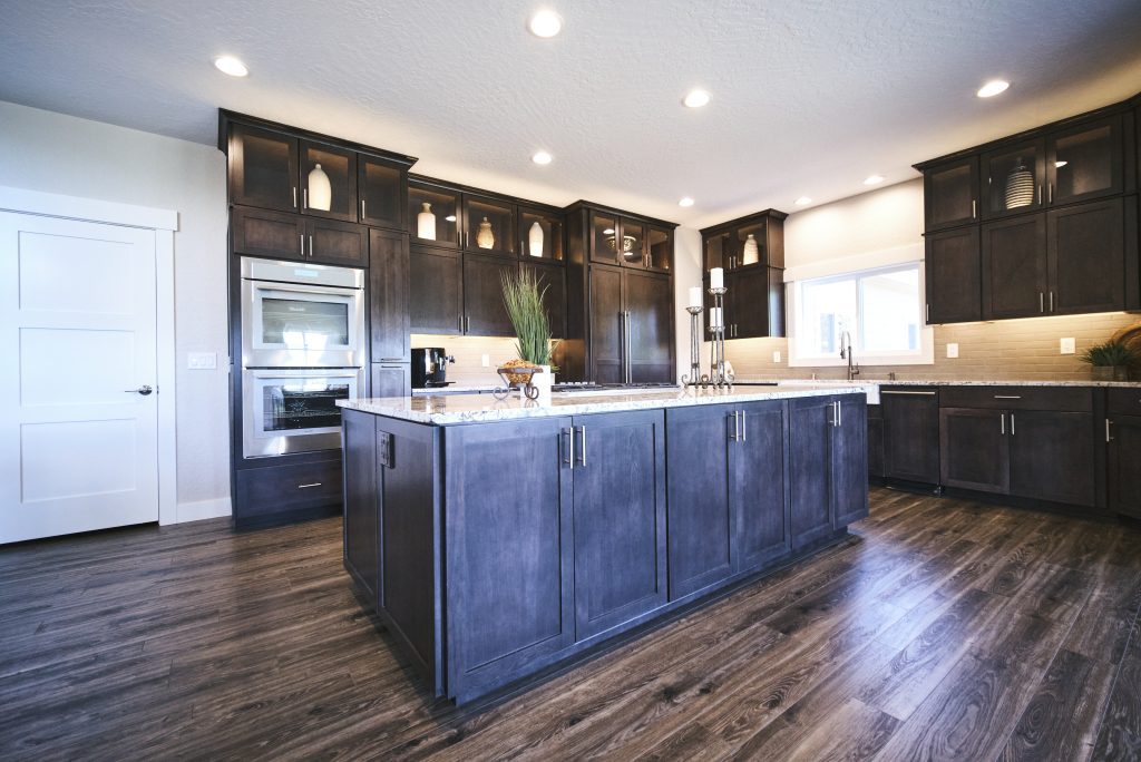 A kitchen with dark cabinets and hardwood floors.
