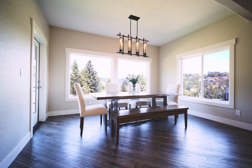 A dining room with hardwood floors and a large window.