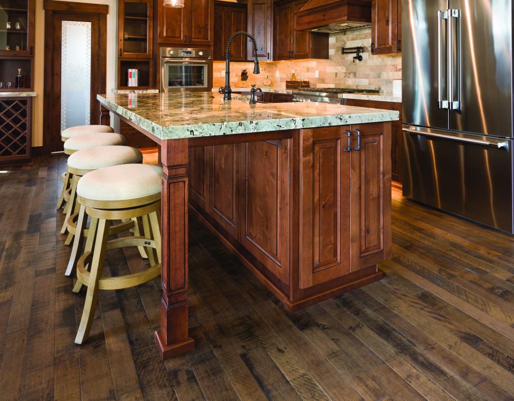 A large kitchen with a center island and bar stools.