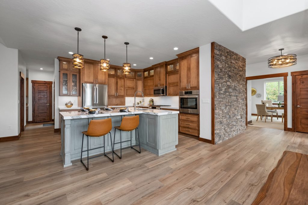A kitchen with wood cabinets and stone counter tops.