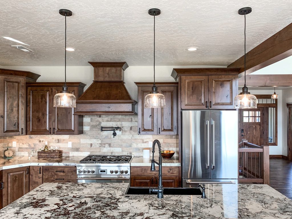 A kitchen with brown cabinets and granite counter tops.