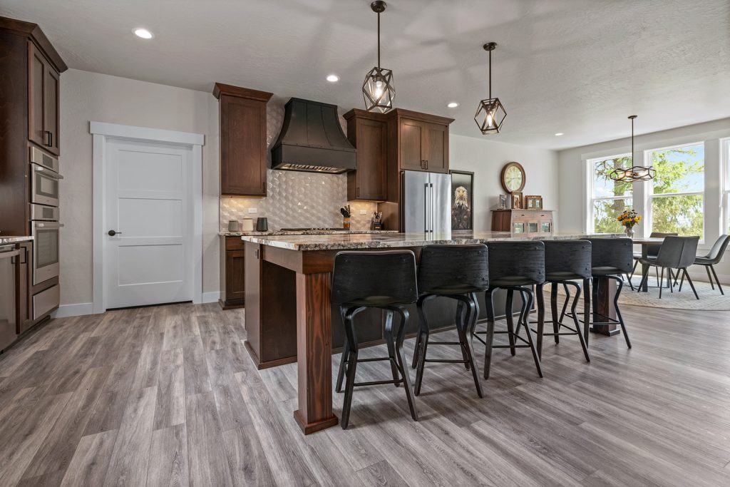 A kitchen with hardwood floors and bar stools.